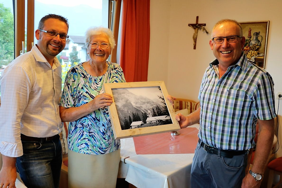 Anna Scharmer schenkt ihr Feldernalmbild den Repräsentanten der Hochfeldern Alm: Dem Almbeauftragen Martin Kapeller und Almobmann Klaus Scharmer. (Foto: Knut Kuckel)